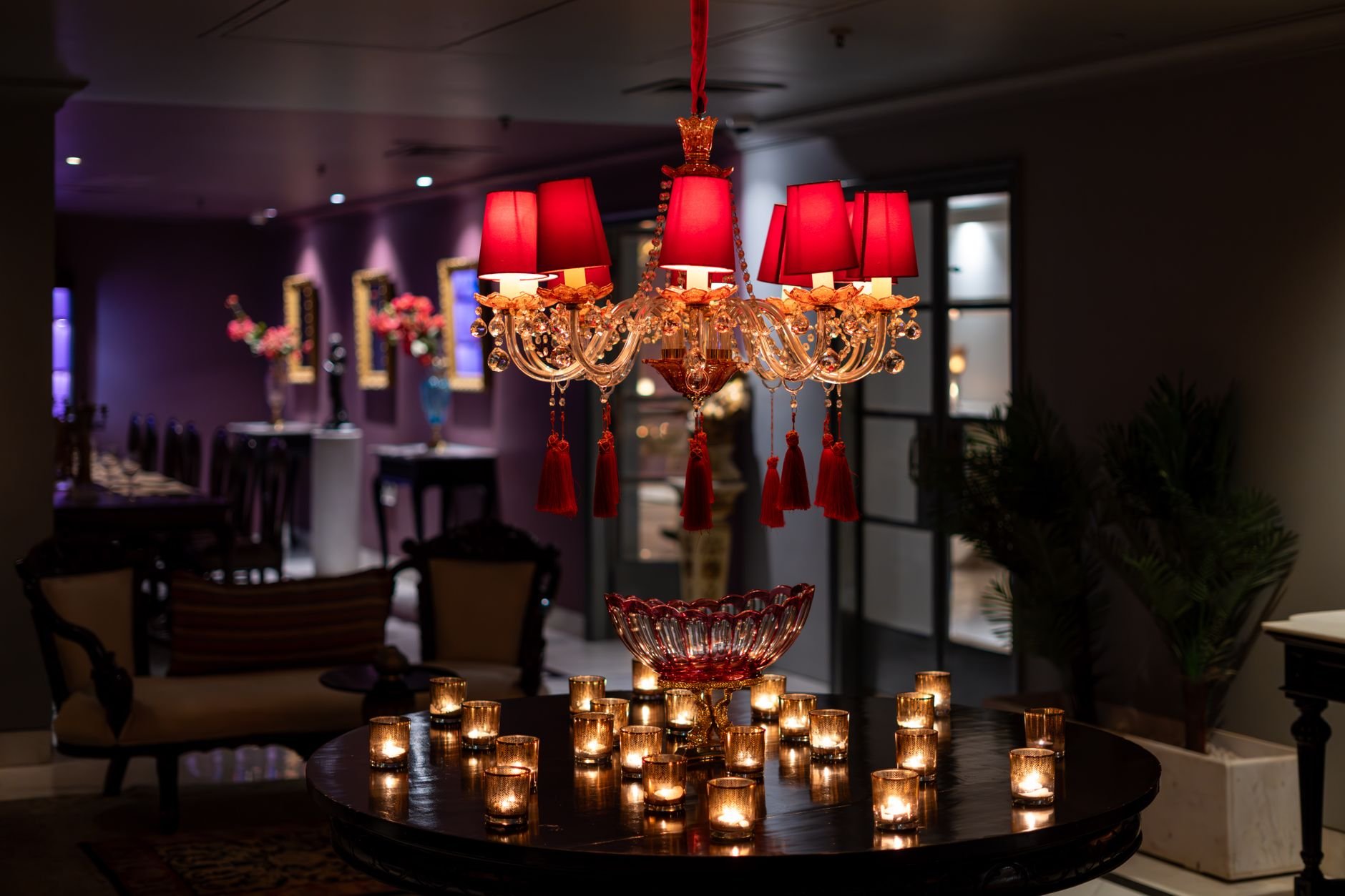Opulent chandelier and warm candlelit ambiance in a luxury hotel.